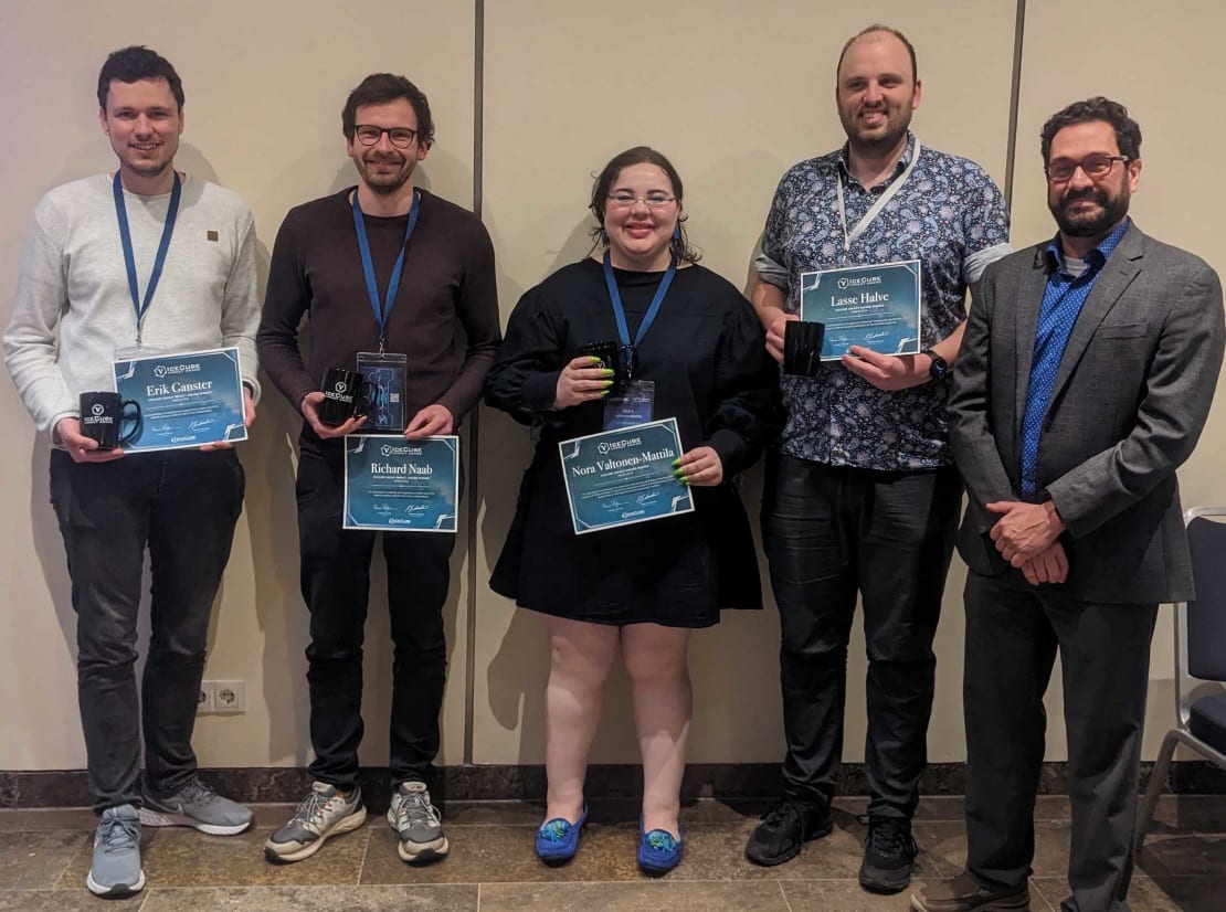 A group of people posing with certificates and mugs