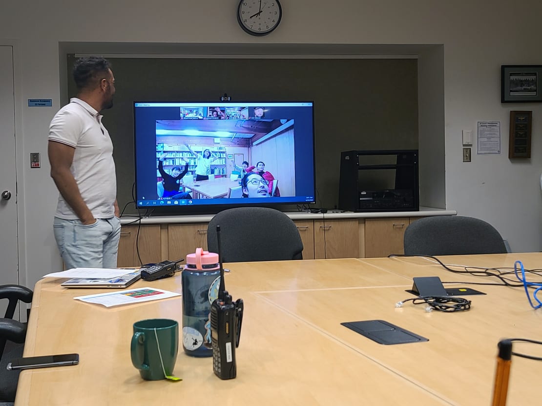 Monitor showing video from other Antarctic station in South Pole station conference room.