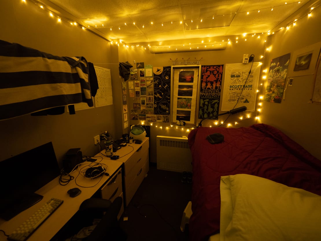 Interior view of living quarters at South Pole station, showing bed, desk, and posters on walls.