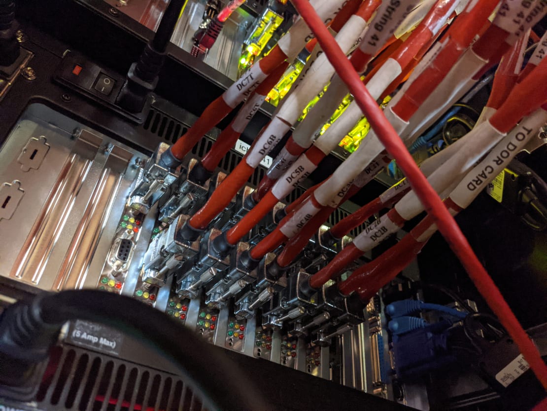 Close-up on a mass of orange cables connected to computer hub.