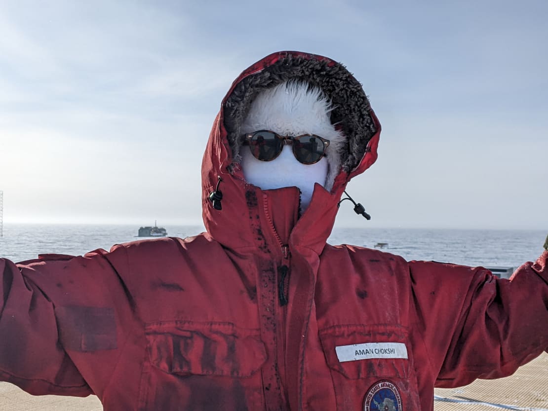 Close-up photo of winterover in red parka and completely covered face with dark sunglasses.