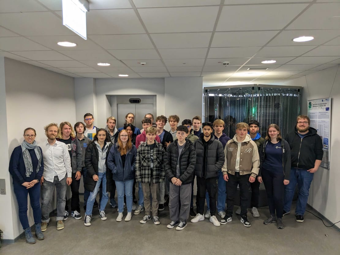 A group of students pose inside a building for a photo