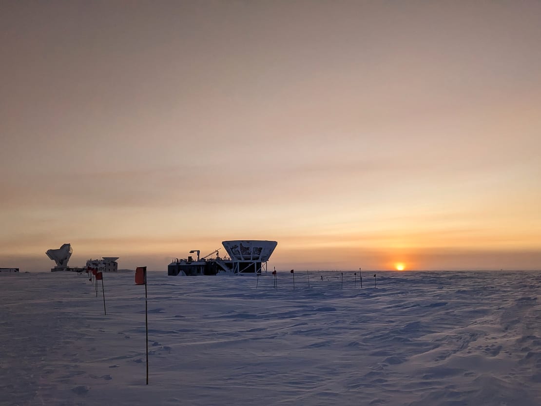 Orange sun on horizon to the right with Dark Sector buildings in shadow to the left, one day before official sunrise.