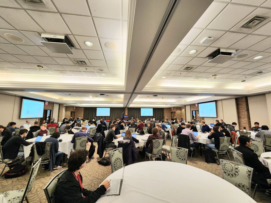 A room full of people sitting at round tables