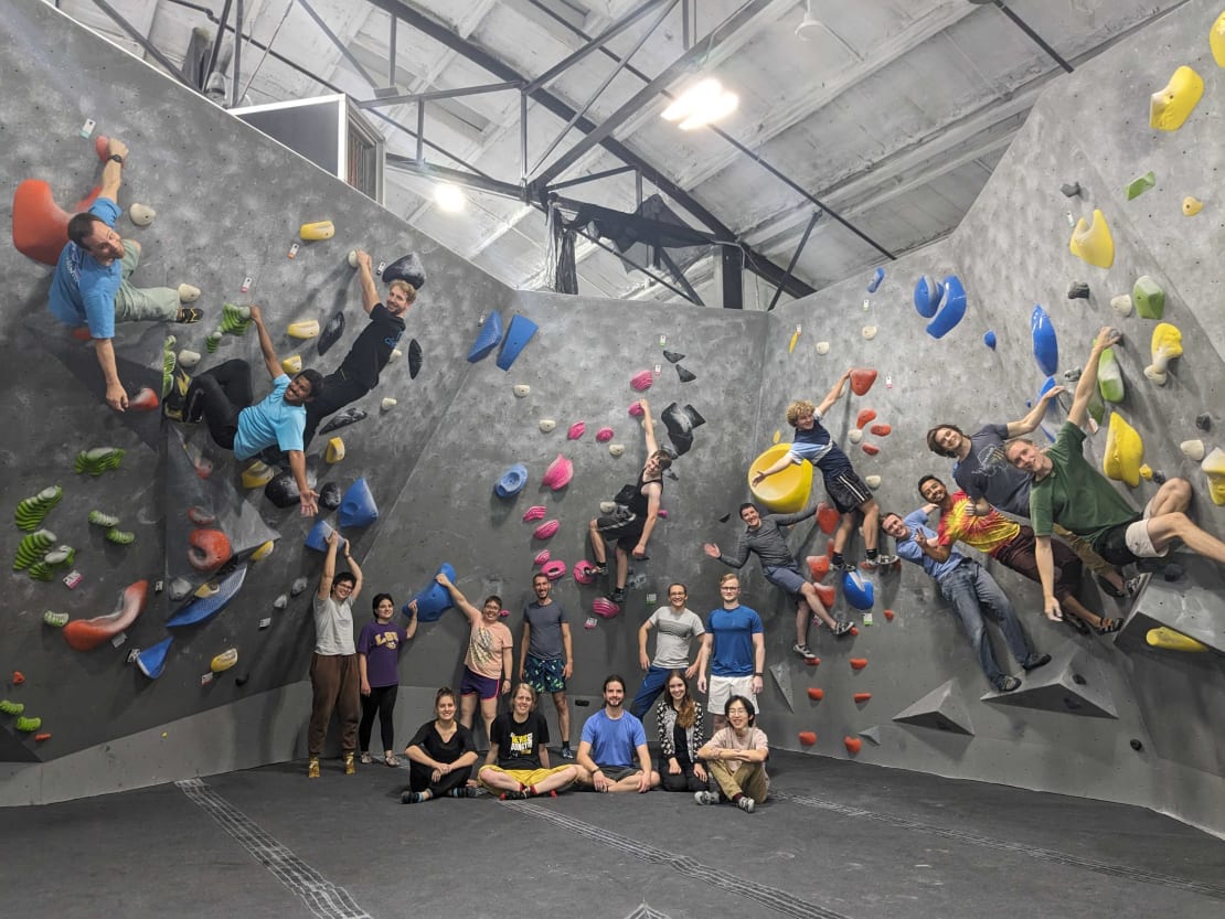 A group of people at a rock climbing gym and posing