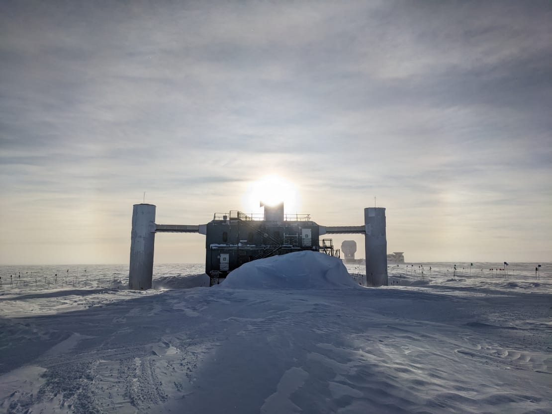 The IceCube Lab with bright sun behind it and faint sun halo.