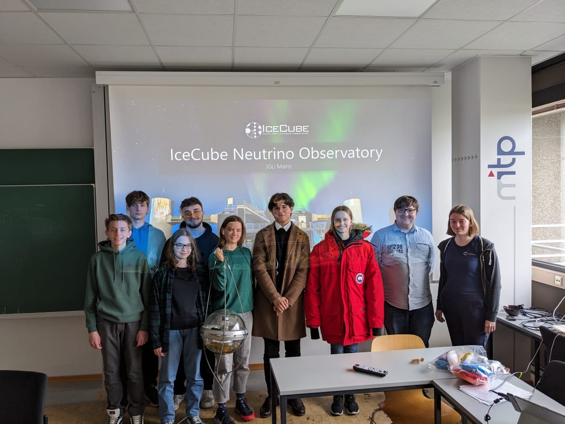 A group of people standing in front of a projector screen