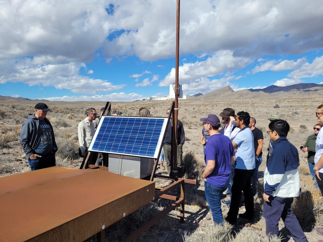 Participants stand in front of the Telescope Array in Delta, Utah