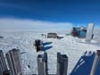 Looking down at the IceCube Lab and a large wrapped-up hose reel from vantage point of nearby drill tower.