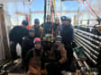 Group photo of nine drillers surrounding a module to be deployed.
