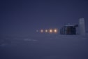 Combined time-lapse image of part of lunar eclipse seen in twilight sky next to IceCube Lab.