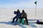 Two new winterovers, seated for a photo out on the ice.