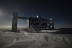The IceCube Lab lit from behind by moonlight.