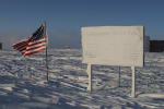 Snow-covered sign at geographical South Pole.