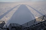 Long shadow of IceCube Lab in early sunrise.