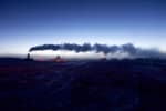 Steam from the South Pole station wafting horizontally across a clear sky after sunset, with lingering light along horizon.