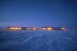 South Pole station at twiglight, with all the windows uncovered and illuminated.