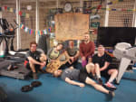 Group photo sitting/lounging among exercise equipment.