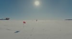 A person walking along the flag line at the South Pole