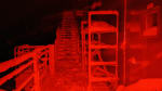 Snow-covered stairs outside South Pole station lit in red light.