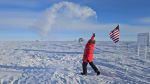 Spray of hot water turning to ice crystals overhead from winterover outside at the Pole throwing water into air.