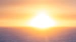 Bright sun on horizon, highlighting texture of the icy surface.