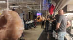 Long view of donuts hanging from strings for a donut eating contest, with people waiting in the wings.