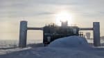 The IceCube Lab with bright sun behind it and faint sun halo.
