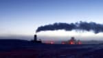 Steam from the South Pole station wafting horizontally across a clear sky after sunset, with lingering light along horizon.