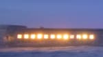 South Pole station at twiglight, with all the windows uncovered and illuminated.