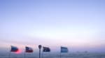 Sky brightening before sunrise, flags at ceremonial Pole flapping in the wind.