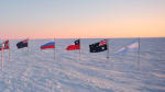 The flags at the ceremonial South Pole at sunrise, just after being replaced for the summer season.