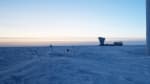 IceCube Lab in foreground, waning sunlight on horizon.