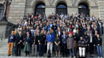 A group photo of people standing on steps in front of a building.