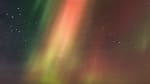 Colorful blaze of auroras filling the sky above the IceCube Lab on the distant horizon.