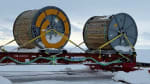 Large spools of cable assemblies on sleds, waiting to be attached to South Pole traverse.