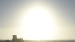 A bright sun “sitting” on the horizon at the South Pole, with the foreground dark and shadowy.