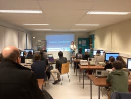 A group of students in a classroom with devices in front of them