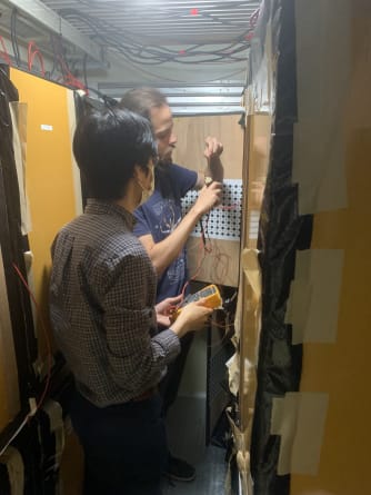 Researchers working for the Final Acceptance Test System in a large freezer