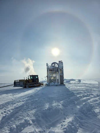Bright sun and halo above drill tower.