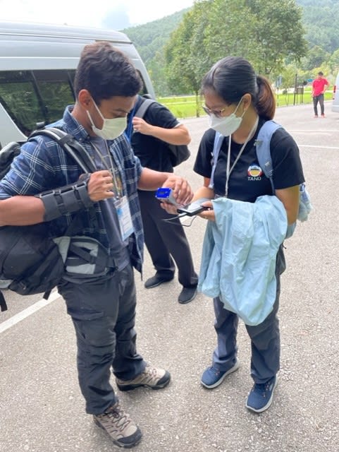 A man showing a woman how to use a cosmic watch detector