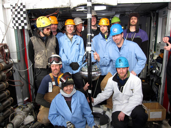 The final deployment team poses with the final DOM in the IceCube array