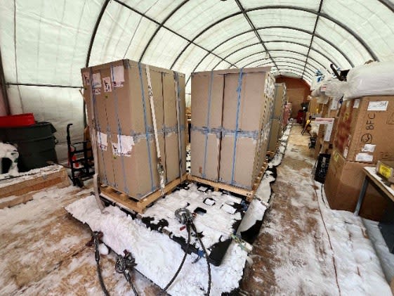 Tall crates on a sled, in an enclosed tent for testing equipment.