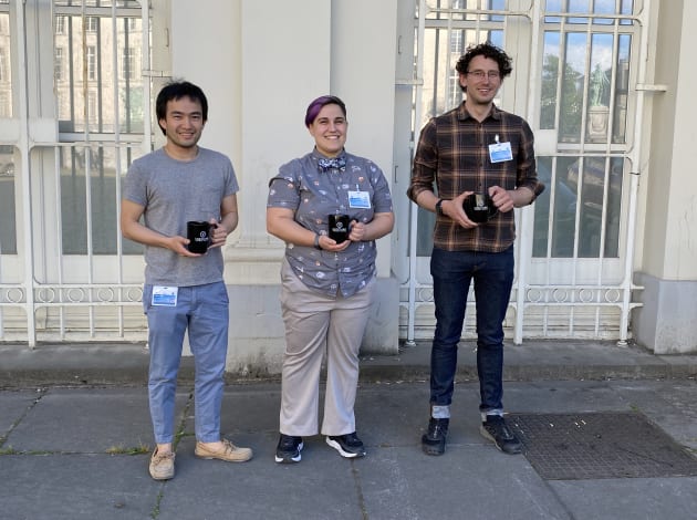 Three of the winners standing next to each other while holding coffee mugs