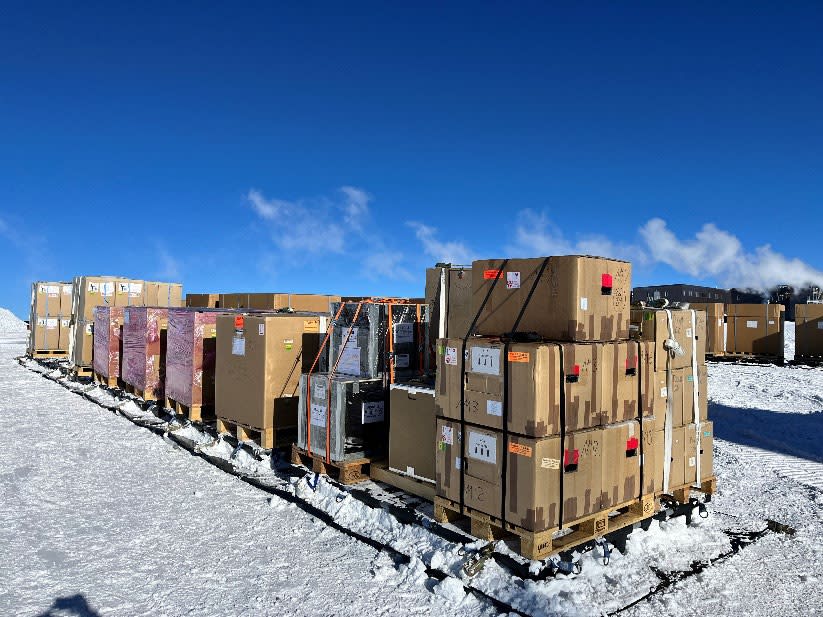 A long line of stacked cargo on sleds out on the snow.