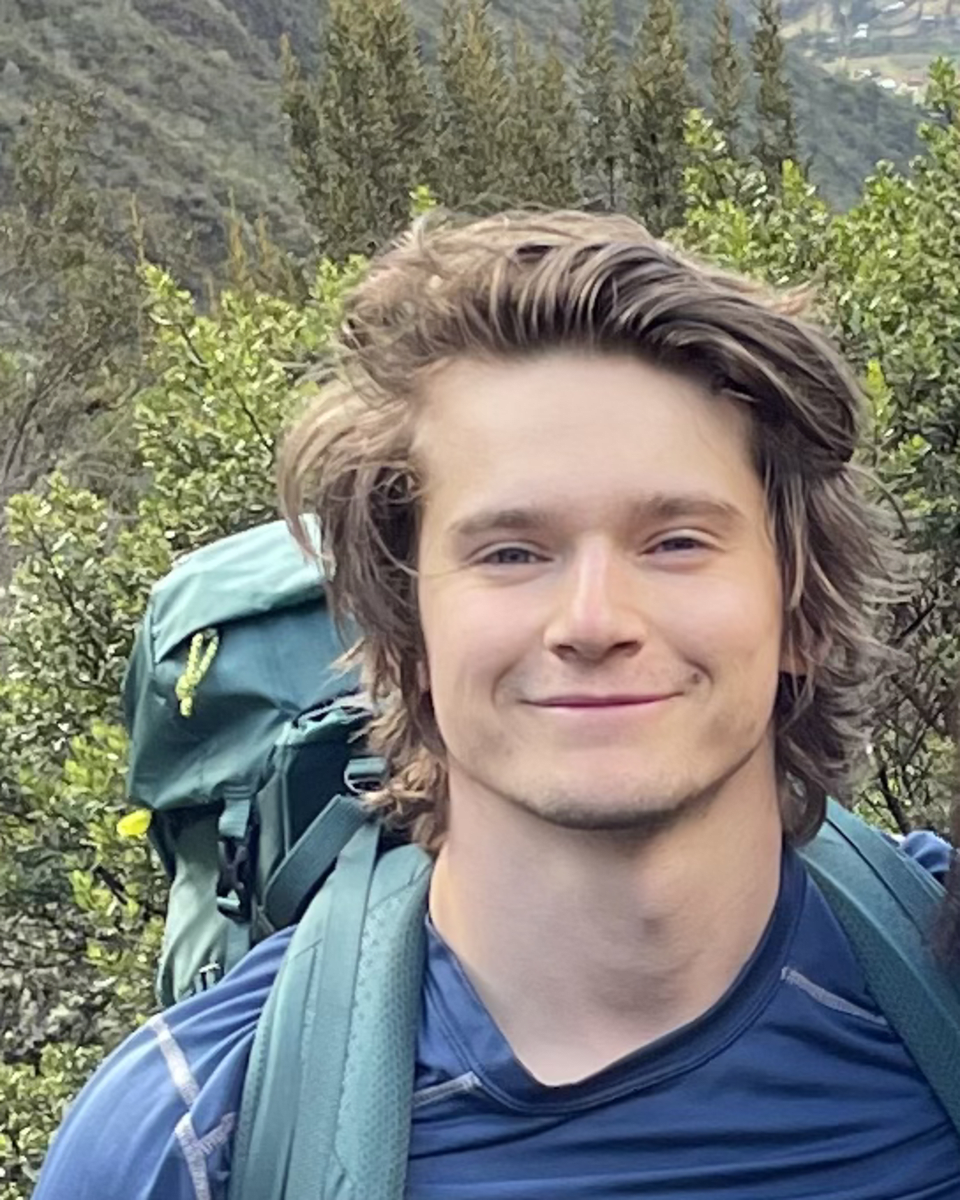 A headshot of a man wearing a bagpack.