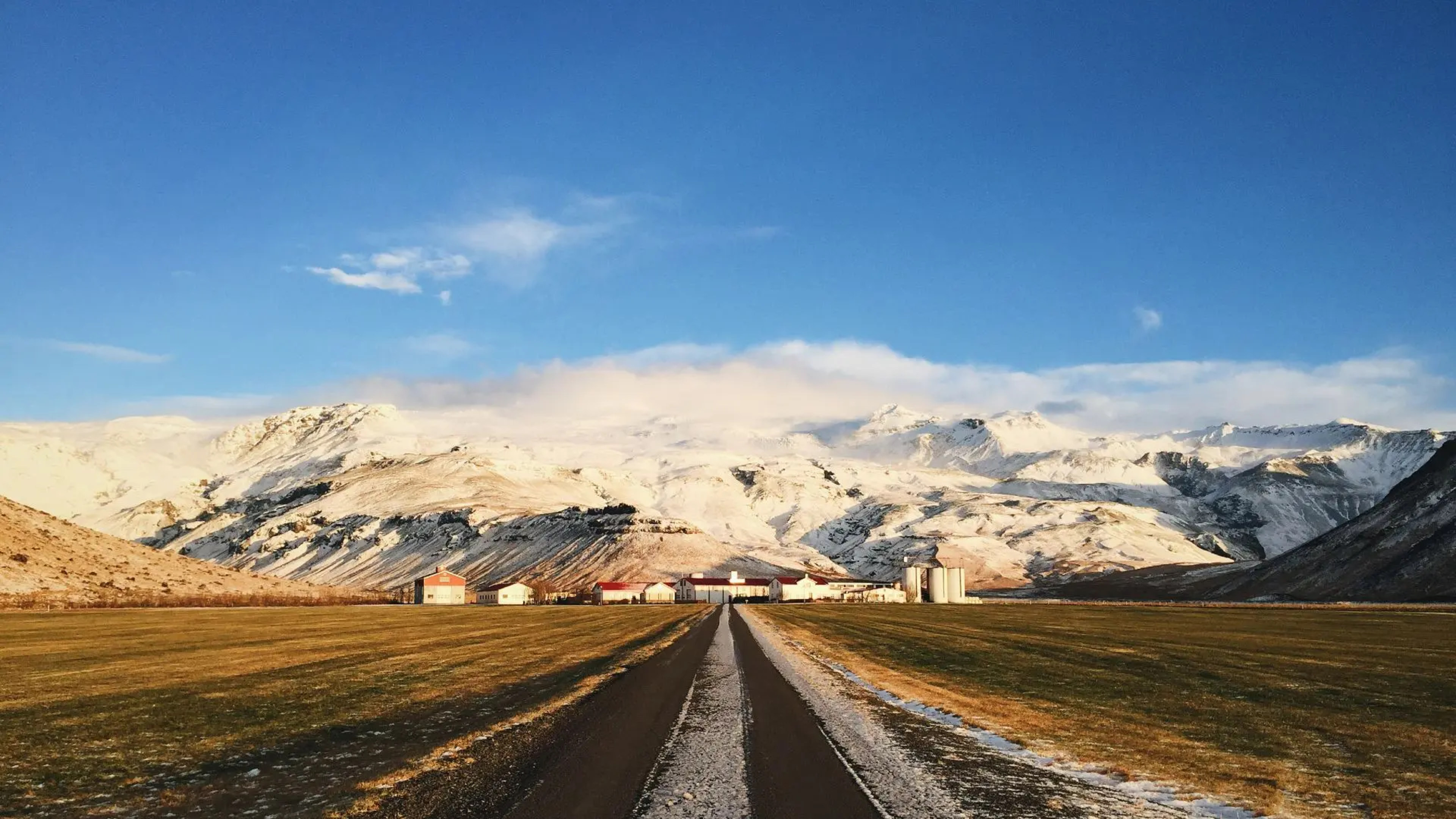 road heading to a village at foot of glacier