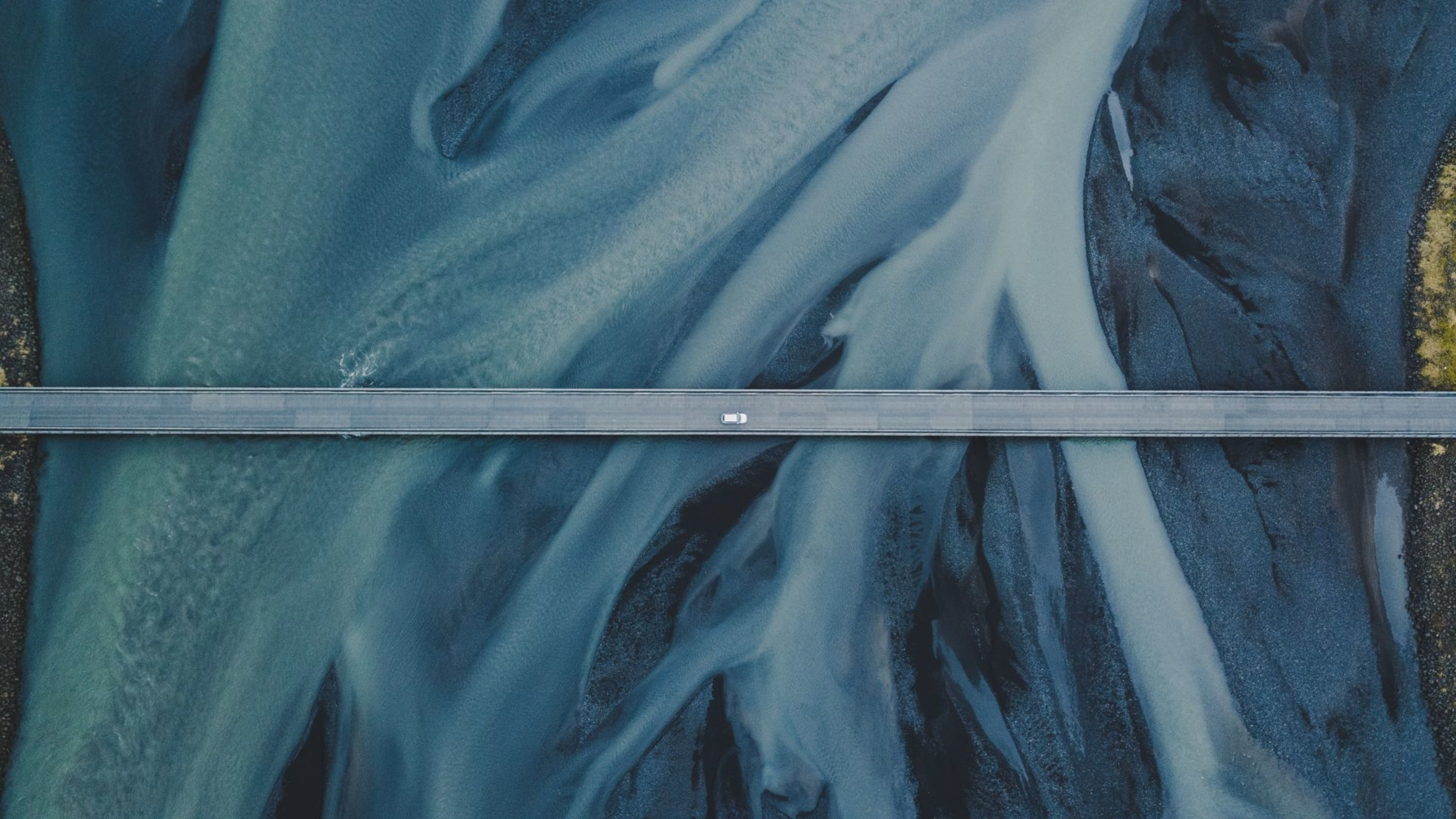 A car on a bridge over a river estuary in Iceland