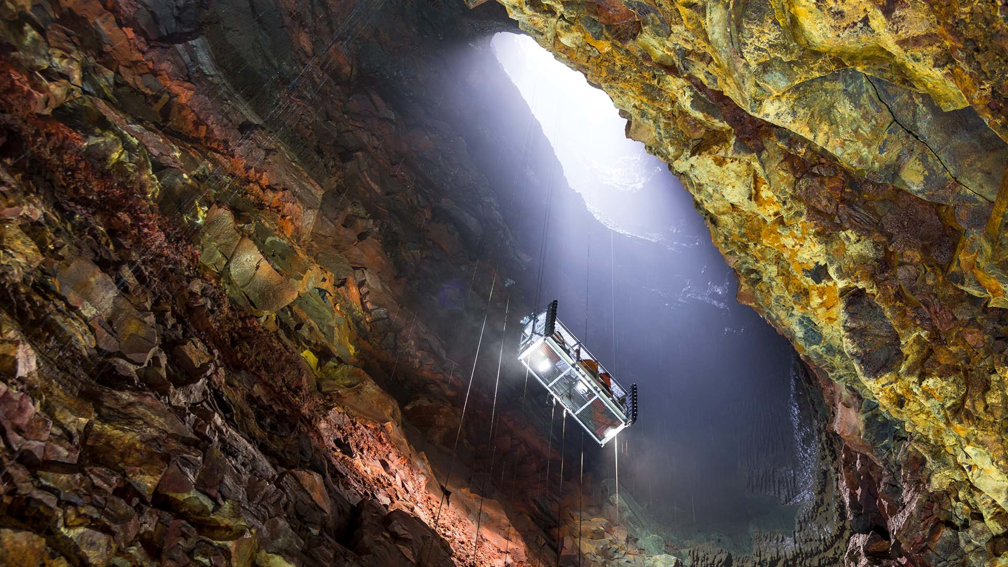 A group of people being lowered into a lava cave © Inside the Volcano