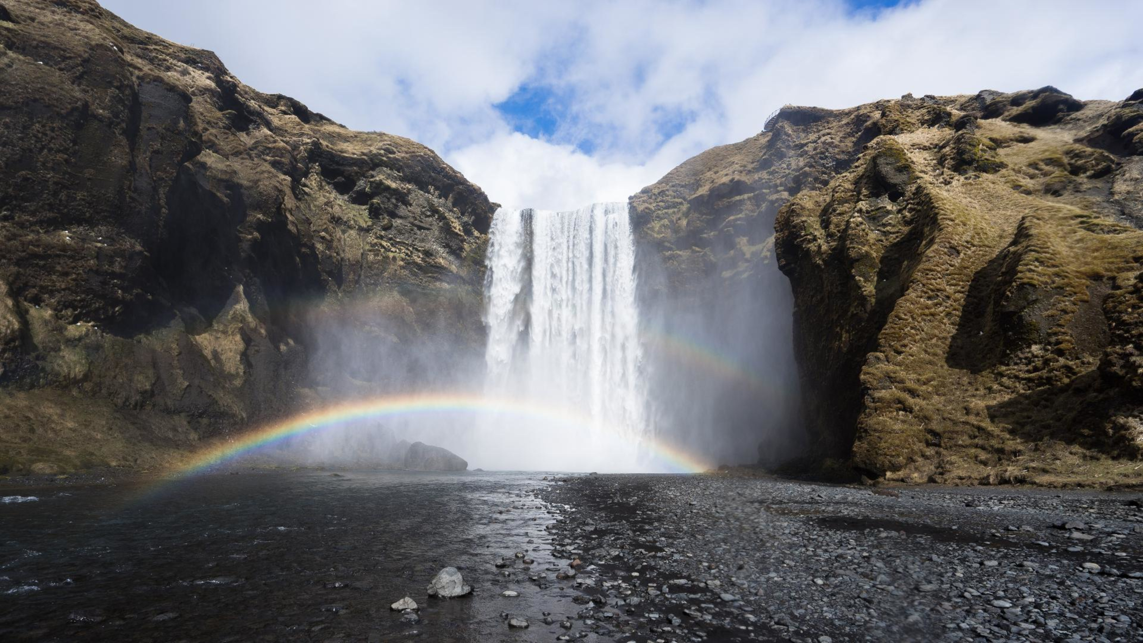 A rainbow over the Skógafoss waterfall on a sunny day